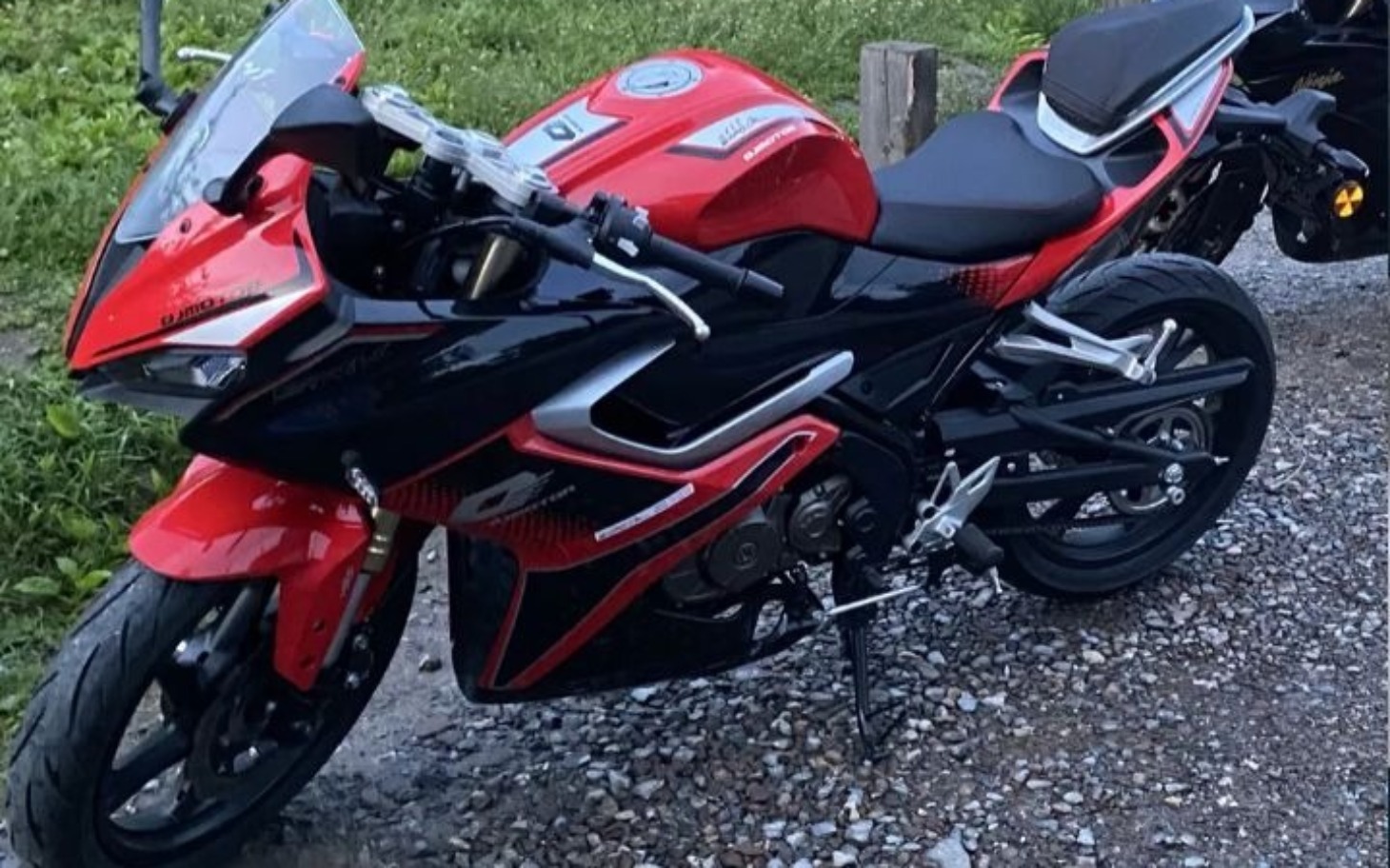 
        Sportowy motocykl w czerwono-czarnym kolorze na drodze.
    