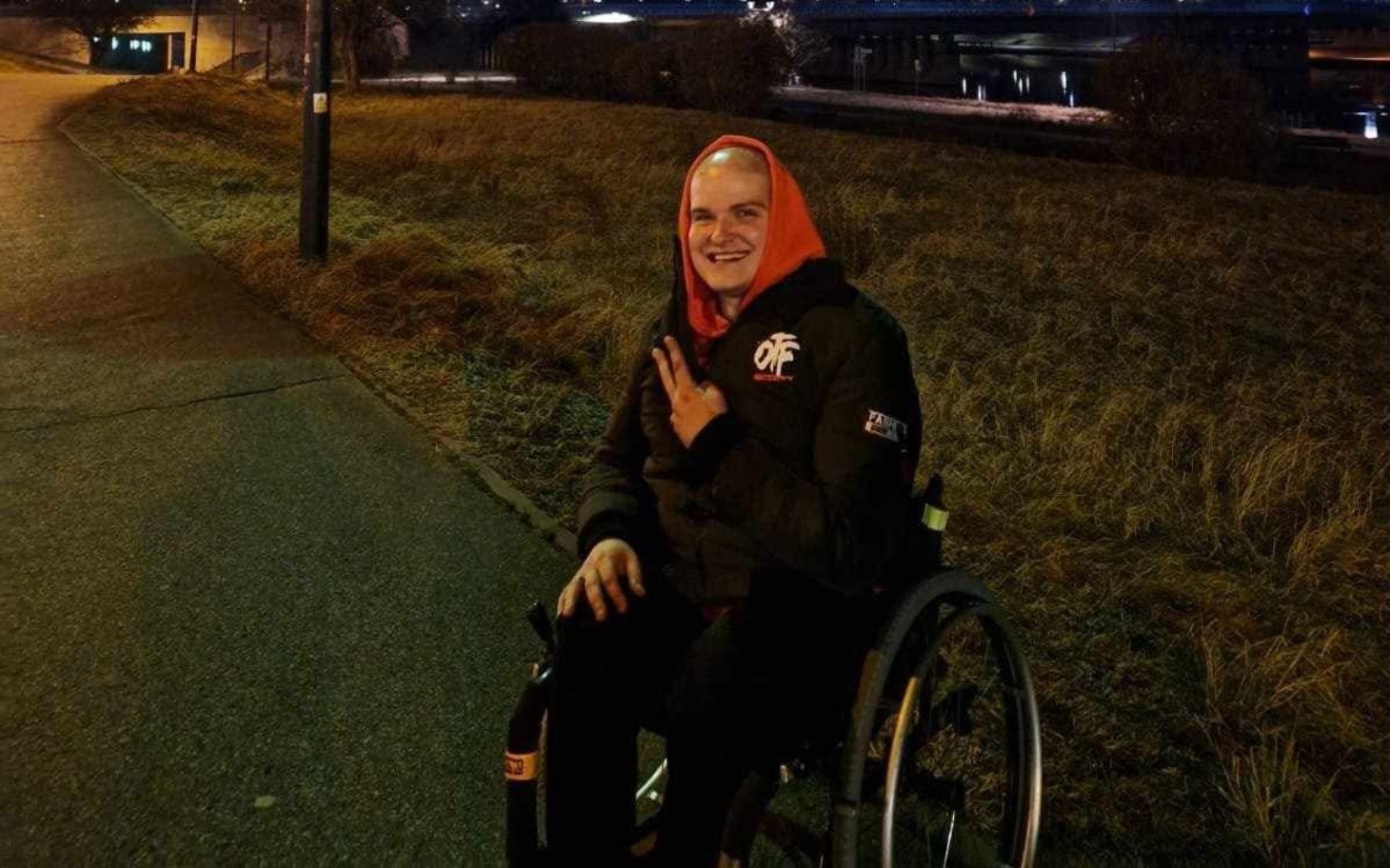 
        Mężczyzna na wózku inwalidzkim, uśmiechający się do kamery.
    