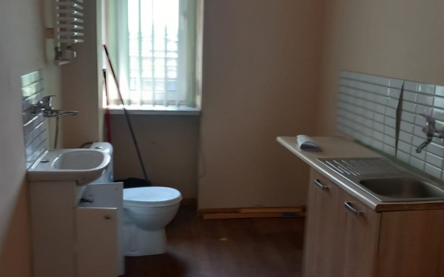 
        Pusty pokój z kuchnią i toaletą.
    