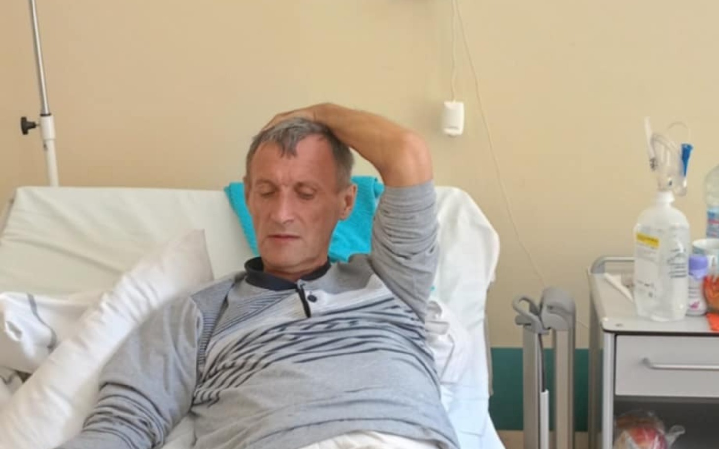 
        Mężczyzna leżący na łóżku w szpitalu.
    