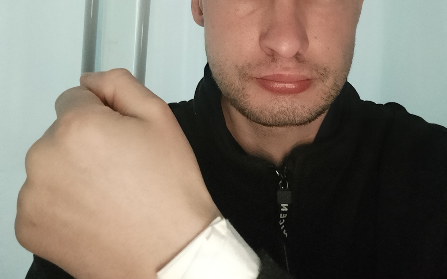 
        Mężczyzna z opatrunkiem na ręce, wyraz twarzy smutny.
    