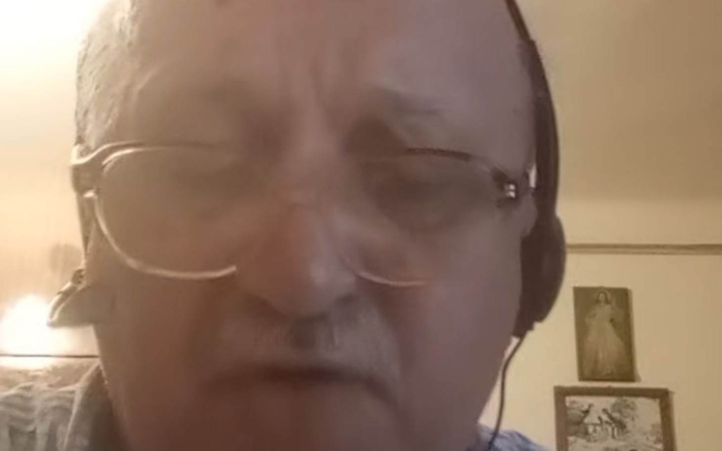 
        Starszy mężczyzna w okularach, rozmawiający przez słuchawki.
    