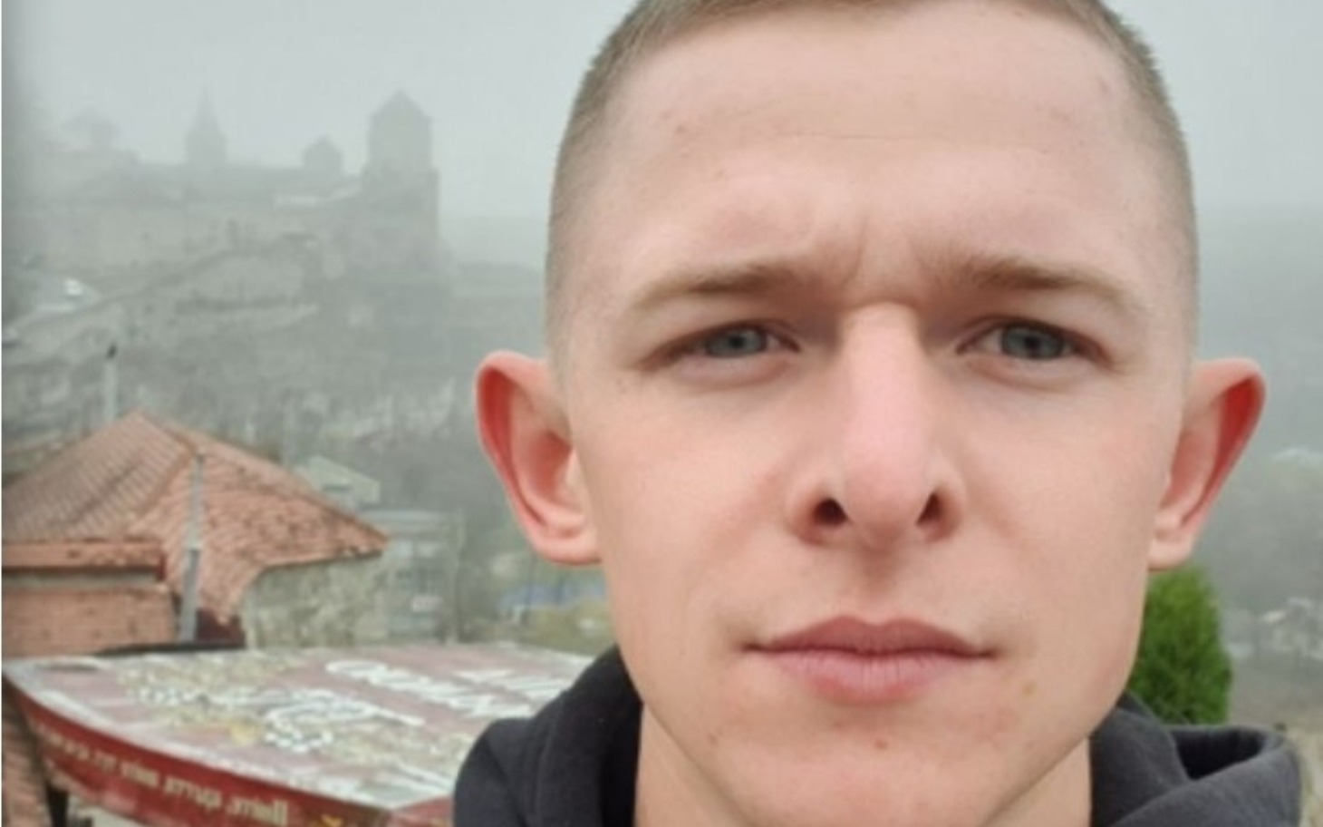 
        Mężczyzna na tle zamku w mglisty dzień.
    