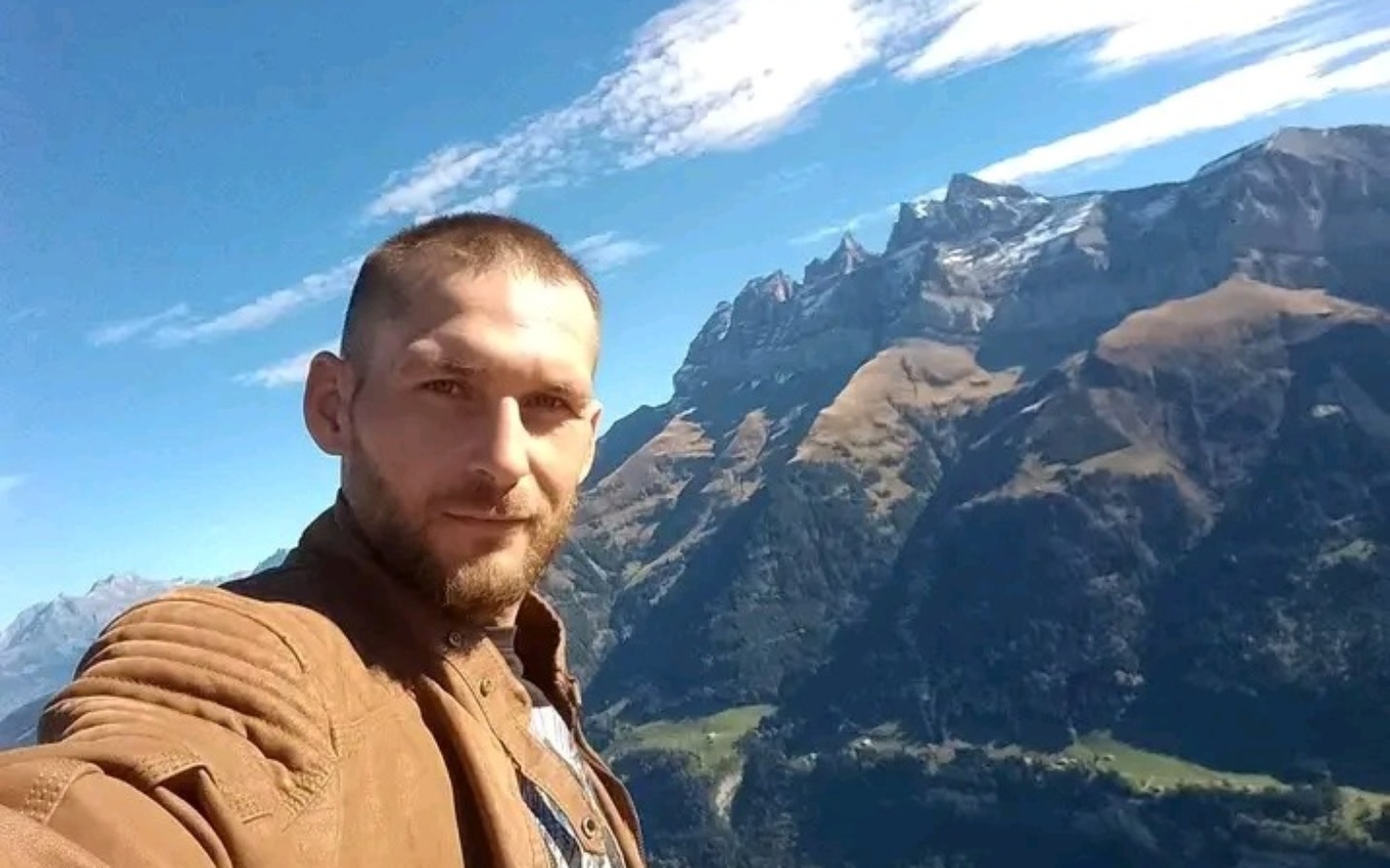 
        Mężczyzna robiący selfie w górach, z pięknym widokiem.
    