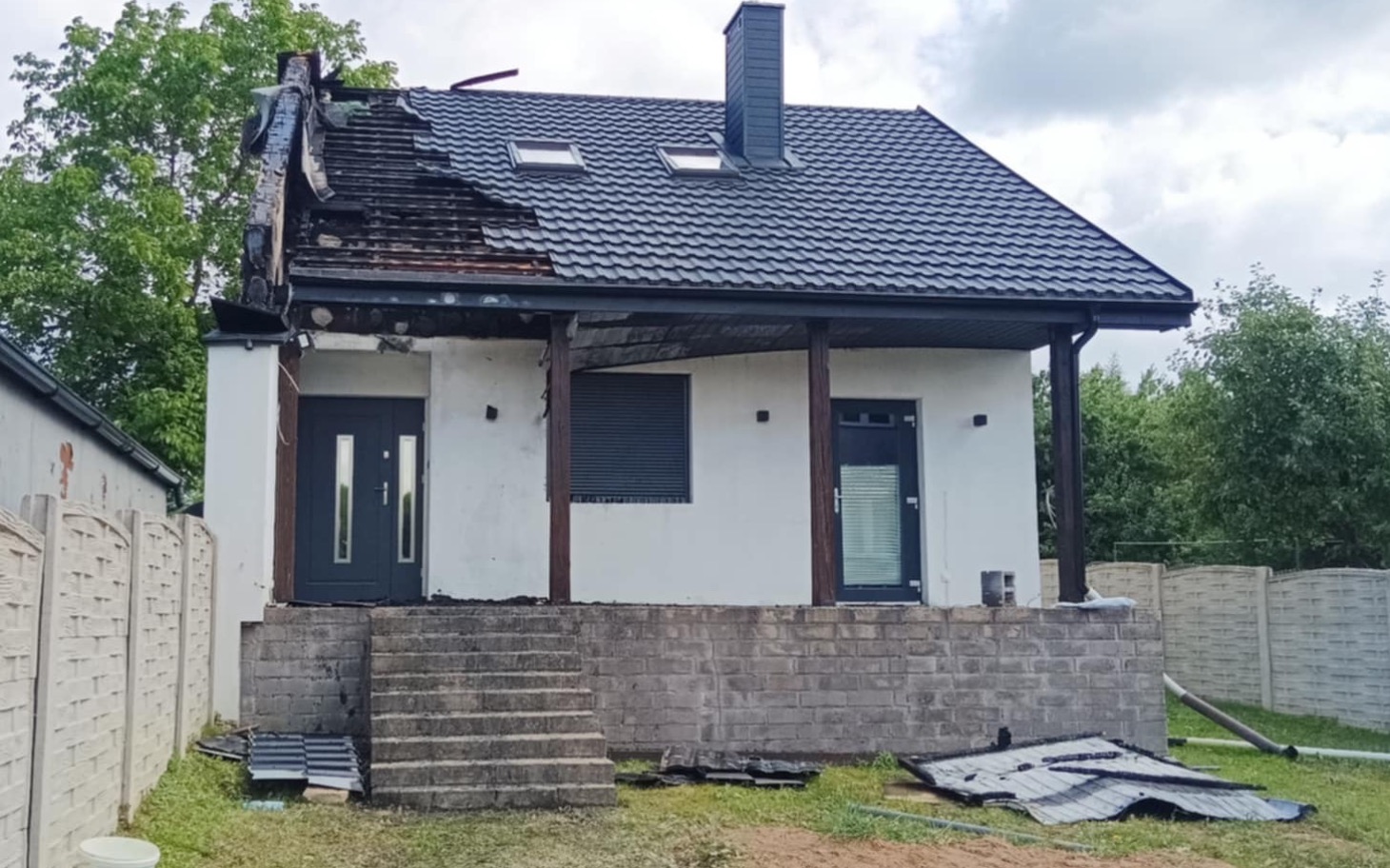 
        Zniszczony dom po pożarze, widok z przodu.
    
