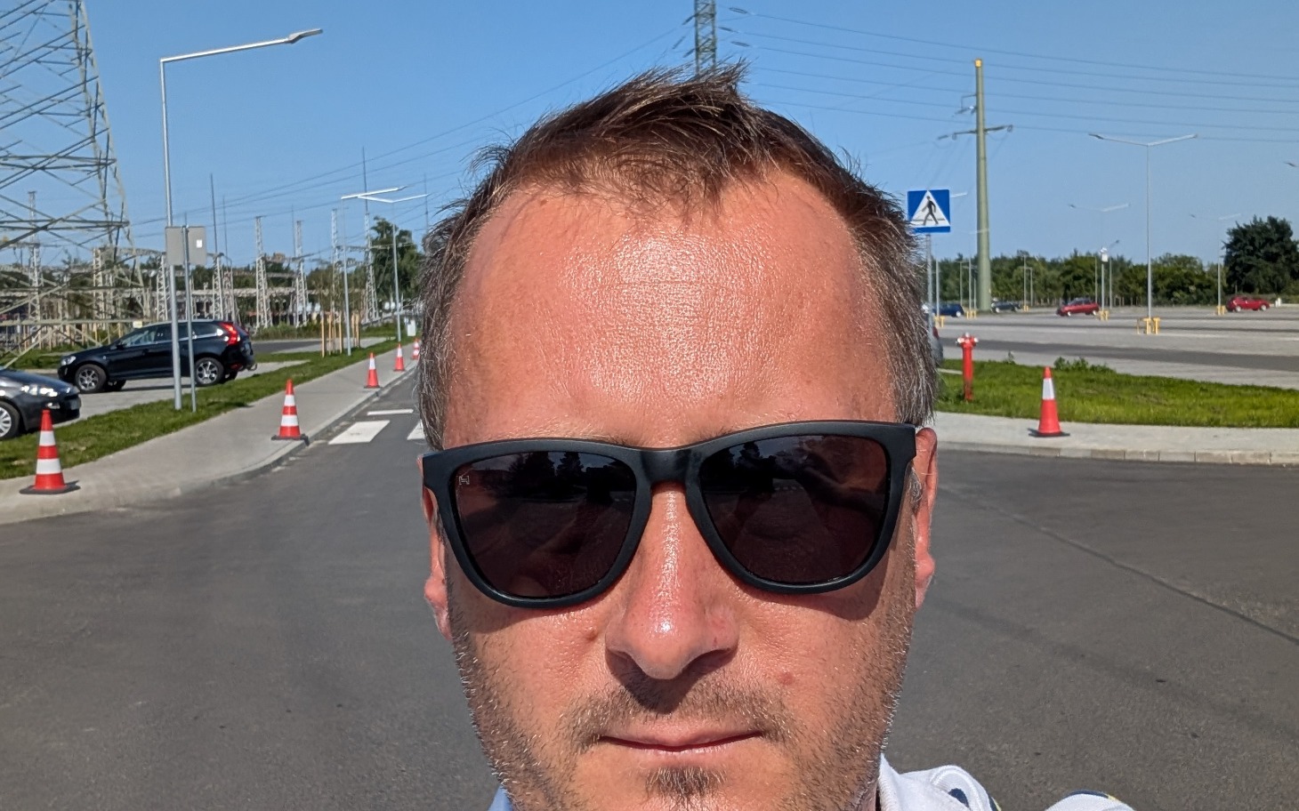 
        Mężczyzna w okularach przeciwsłonecznych na drodze.
    