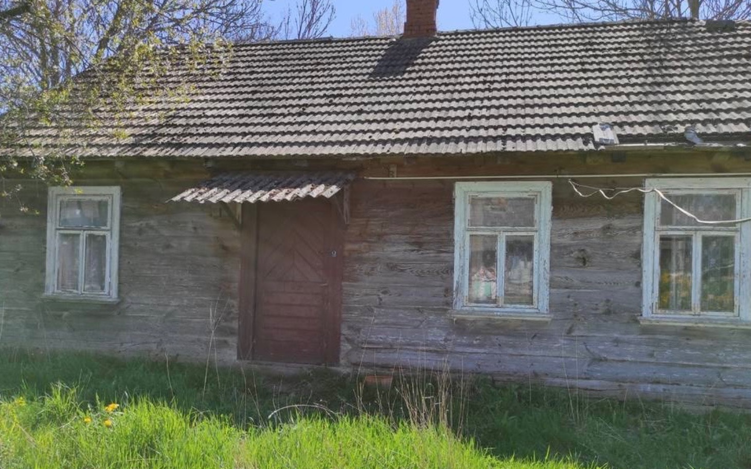 
        Zabytkowy drewniany dom z oknami w stylu wiejskim.
    