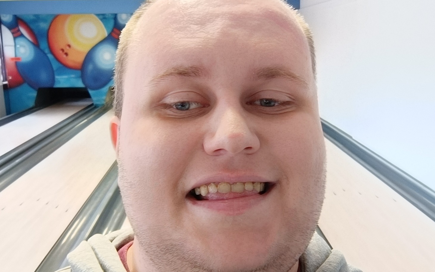 
        Mężczyzna w bowlingu, uśmiechający się do kamery.
    