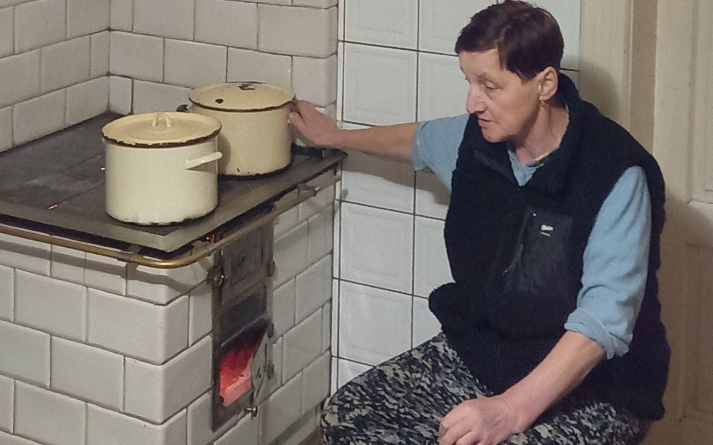 
        Kobieta gotująca na piecu w kuchni.
    