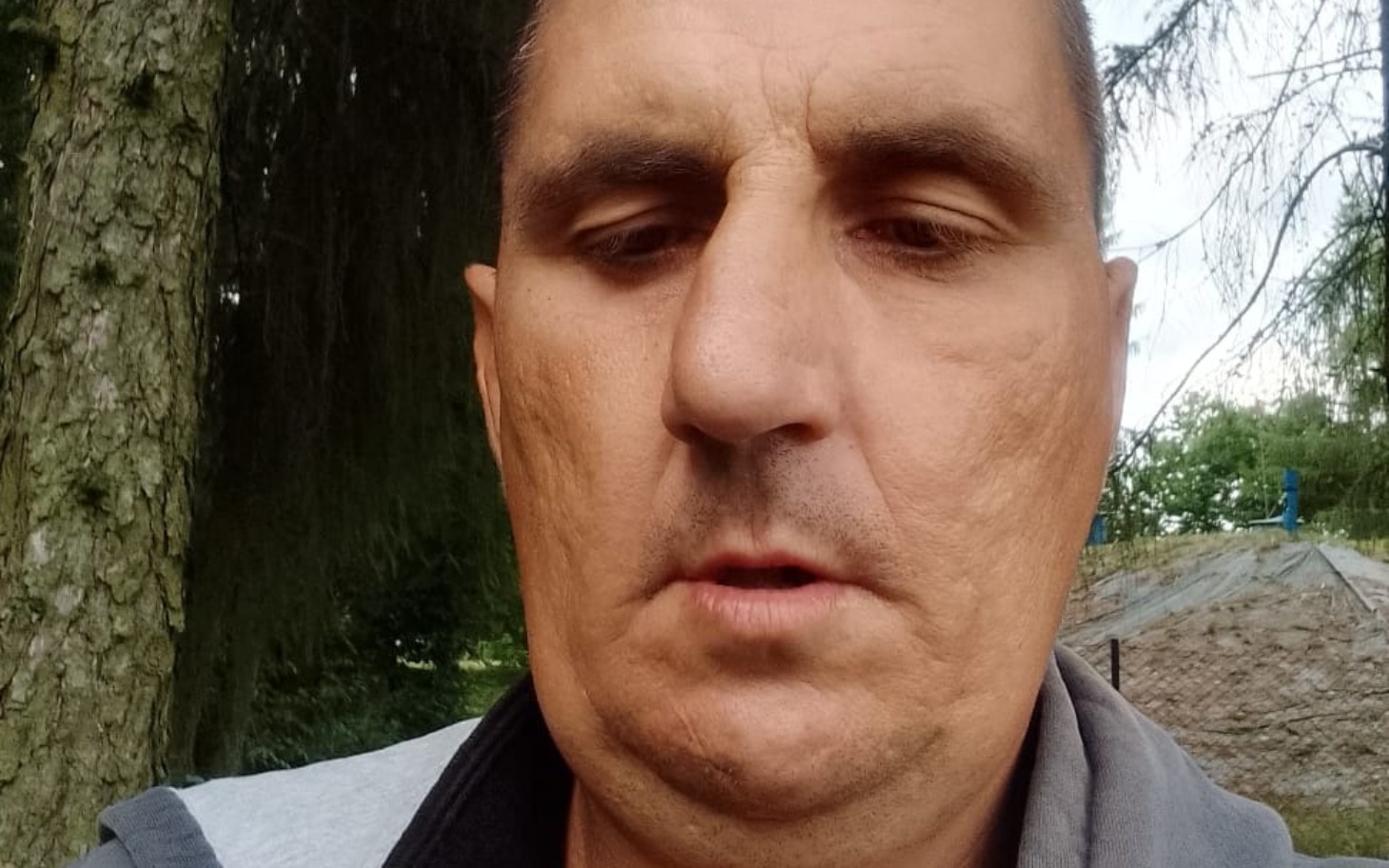 
        Mężczyzna w bliskim ujęciu, z poważnym wyrazem twarzy.
    