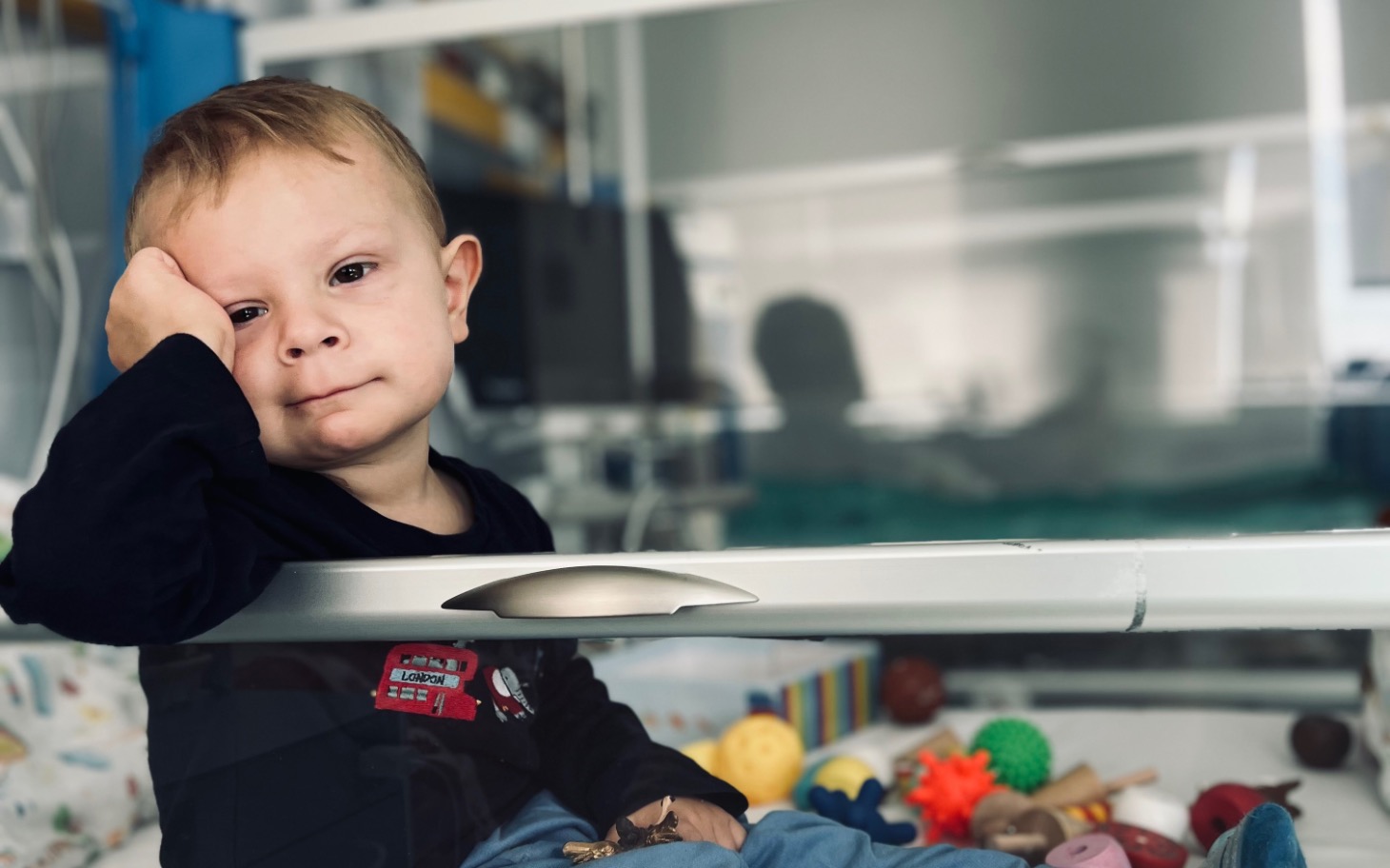 
        Dom z szarymi ścianami, otoczony zielenią i drewnianym płotem.
    