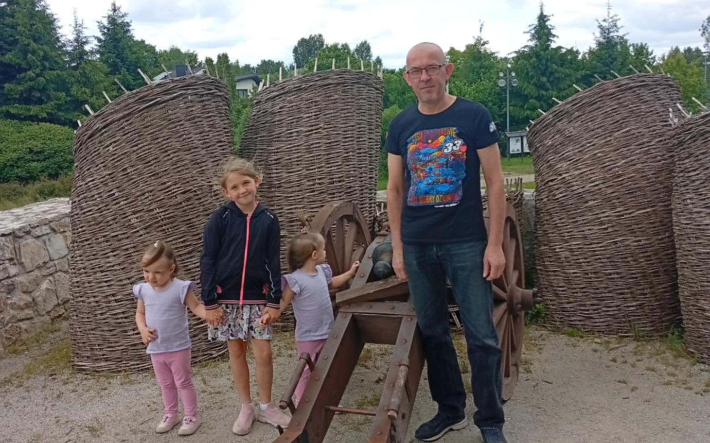 
        Rodzina z dziećmi przy starym urządzeniu rolniczym.
    