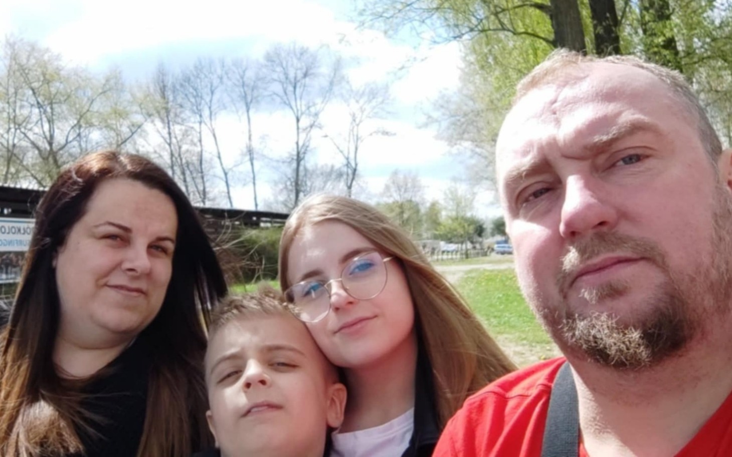 
        Rodzina pozująca do zdjęcia na świeżym powietrzu.
    