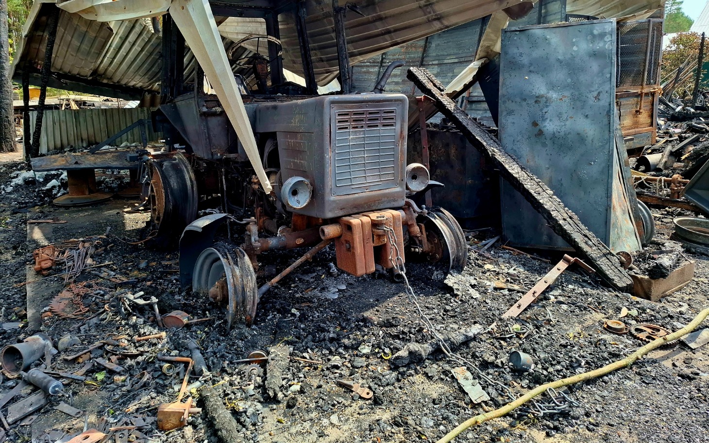 
        Zniszczony traktor w opuszczonym miejscu po pożarze.
    