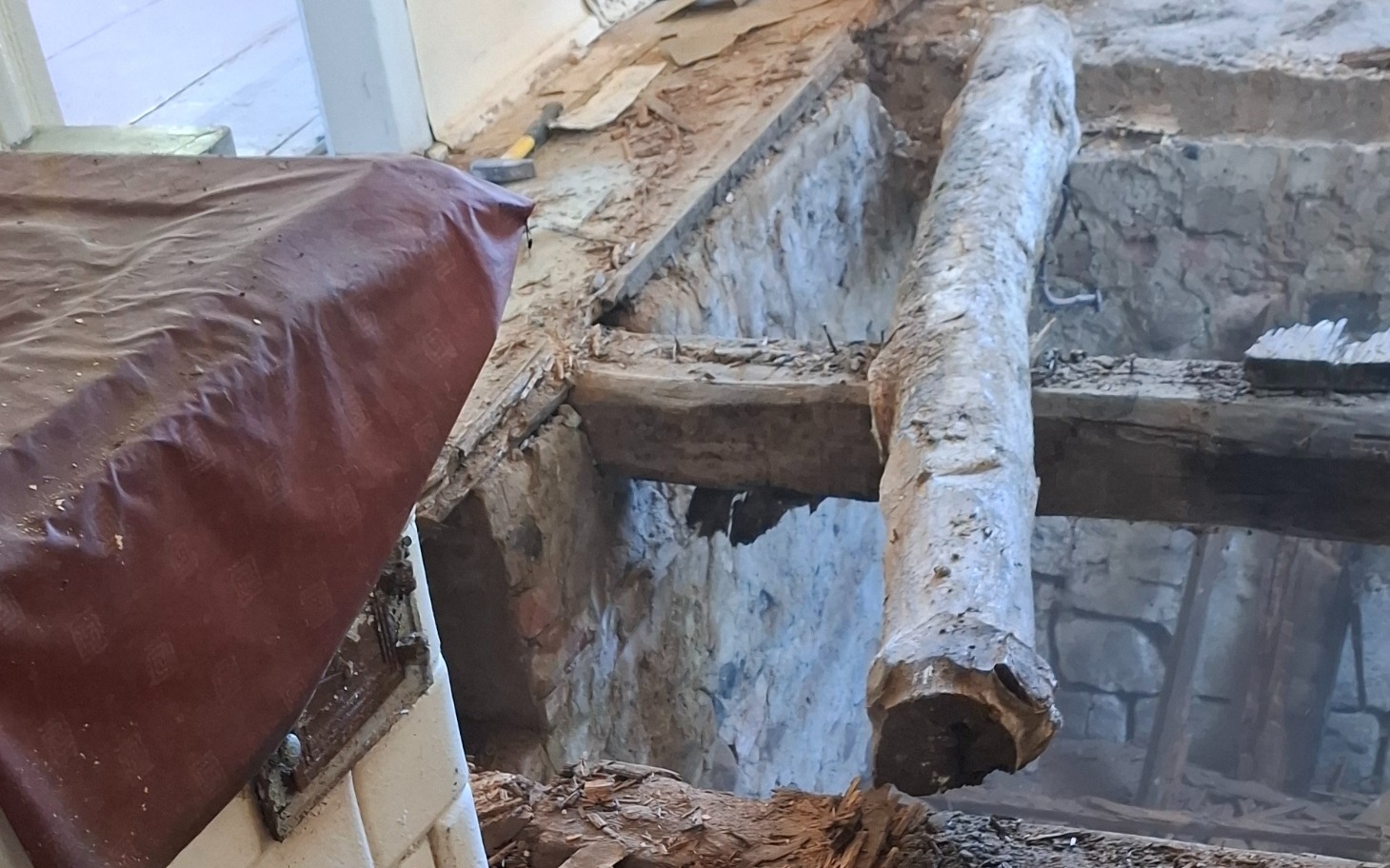 
        Zniszczona podłoga z widocznym drewnem i uszkodzeniami.
    