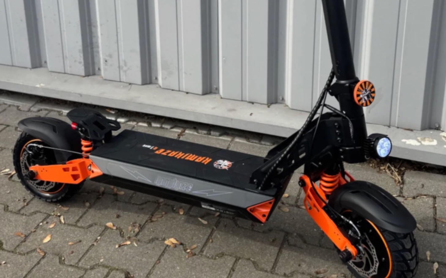 
        Nowoczesna hulajnoga elektryczna w kolorze czarno-pomarańczowym.
    