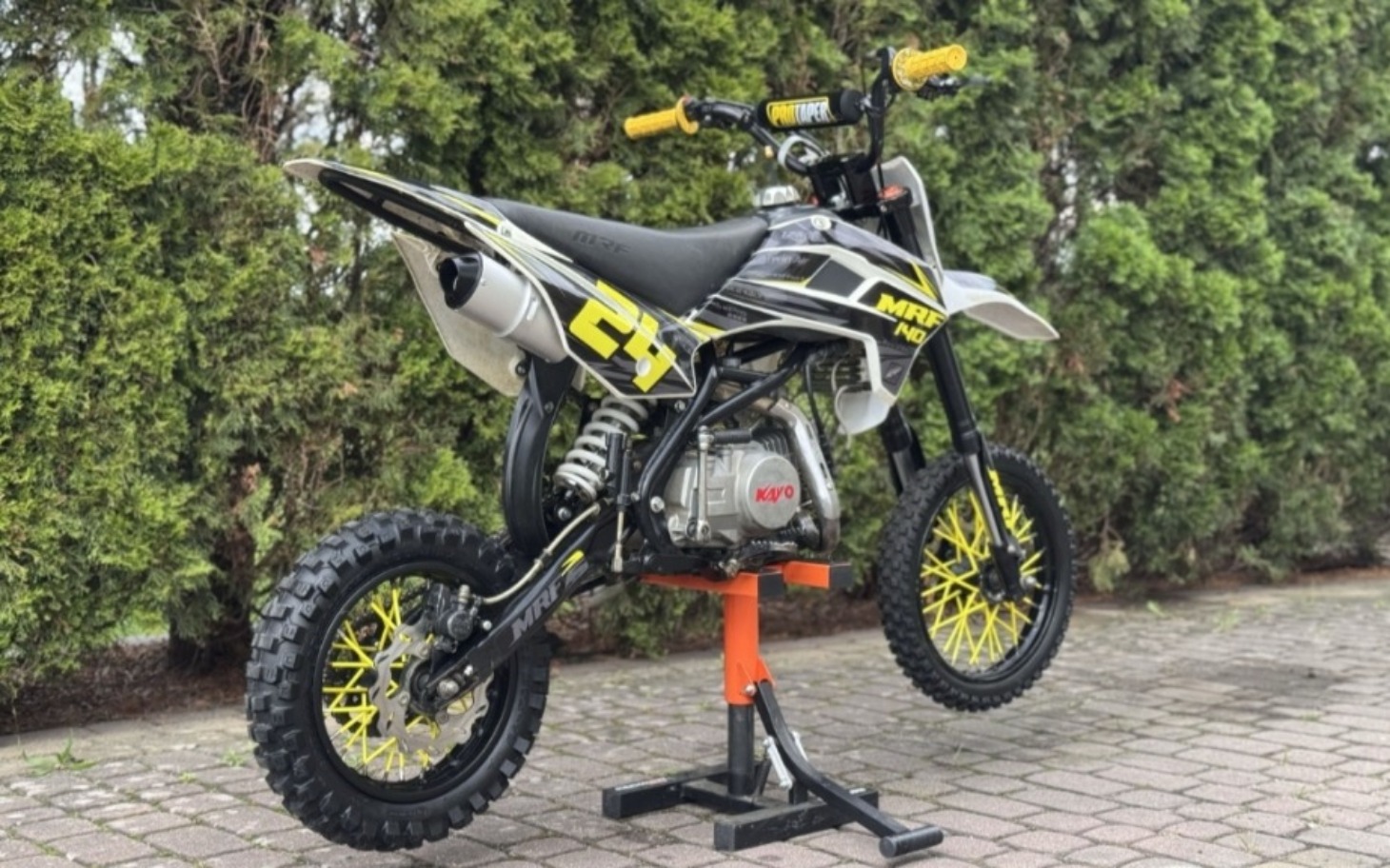 
        Motocykl na stojaku w ogrodzie.
    