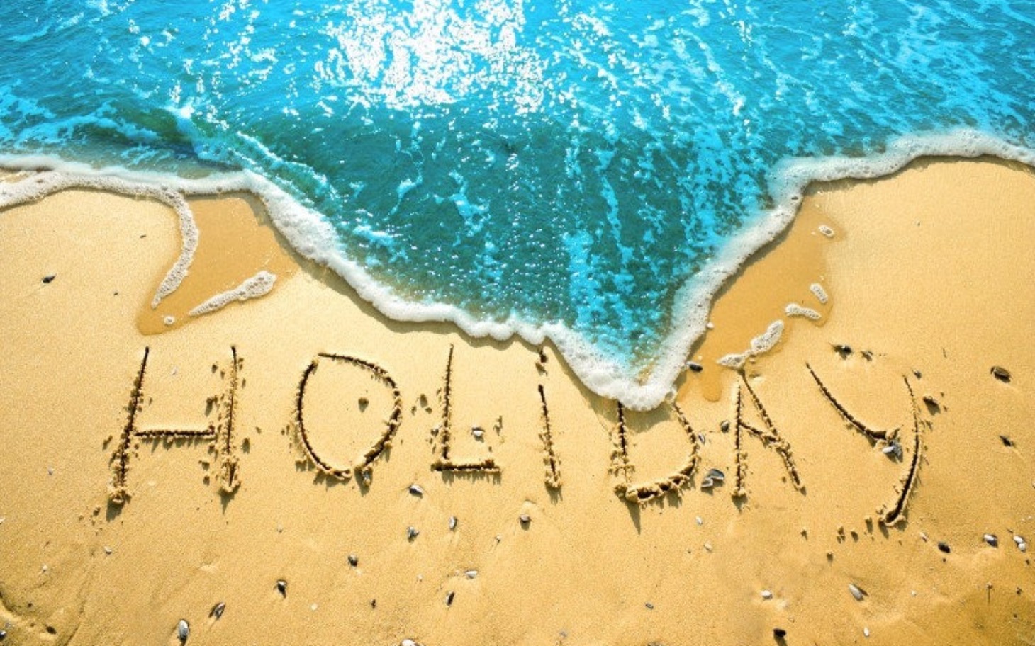 
        Plaża z napisem 'HOLIDAY' na piasku.
    