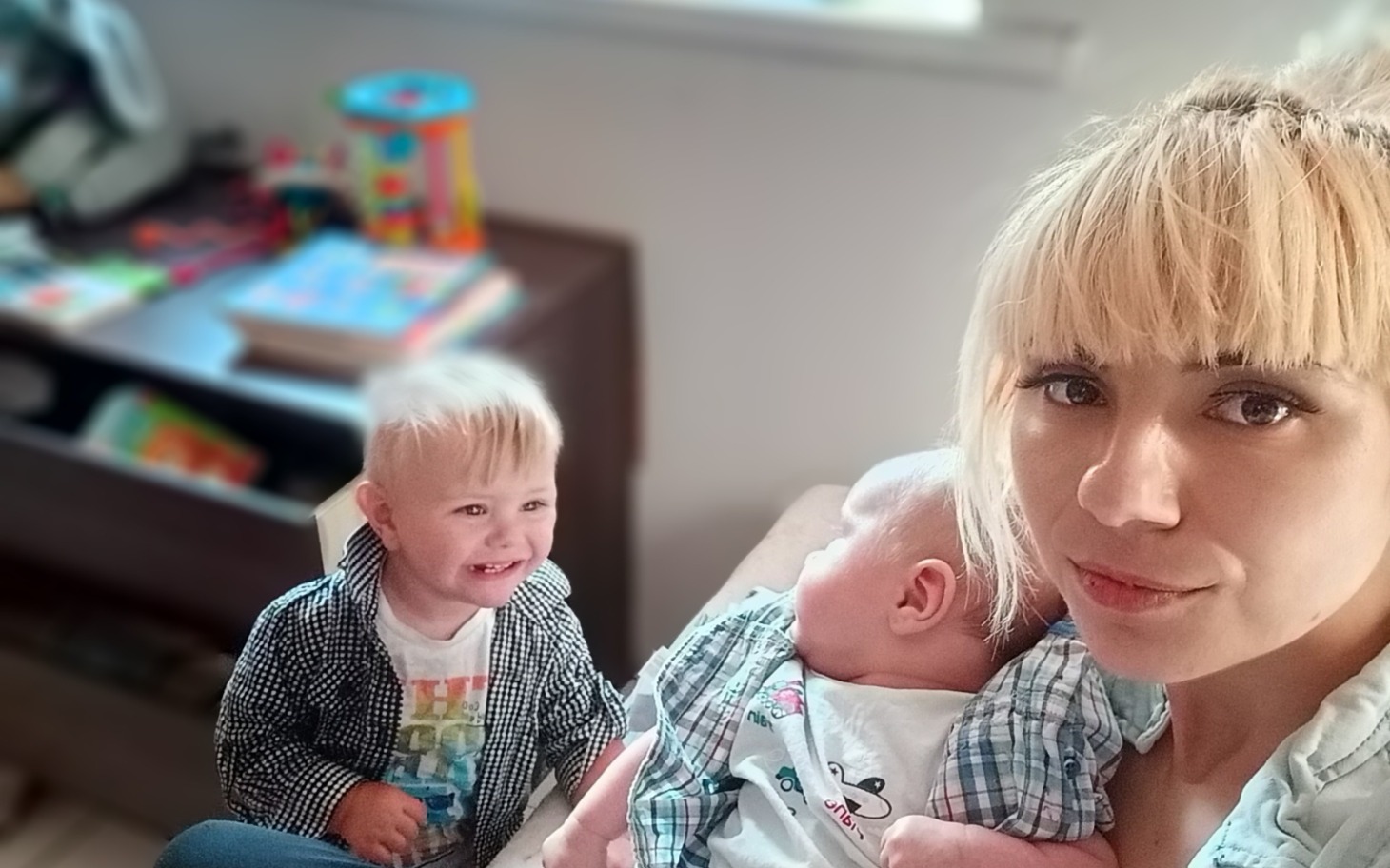 
        Mama z dwójką dzieci w przytulnym wnętrzu.
    