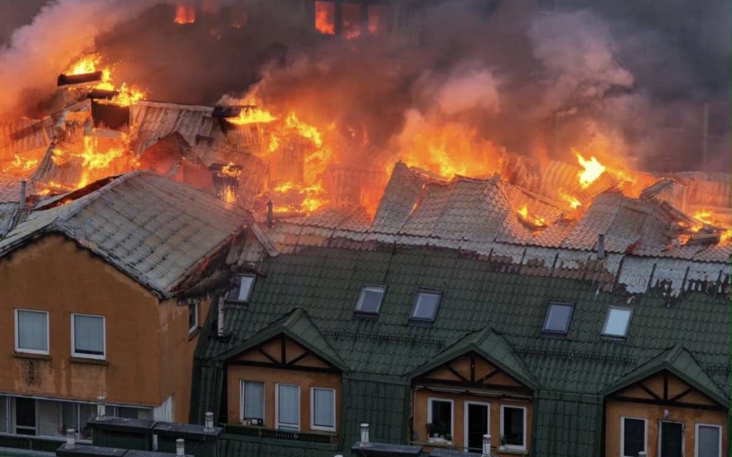 
        Pożar budynku, z płomieniami i dymem w tle.
    