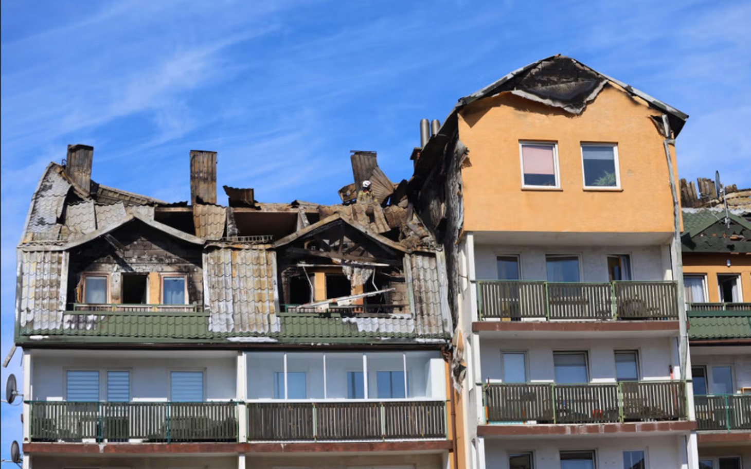 
        Zniszczony dach budynku, widoczne uszkodzenia i wypalone fragmenty.
    