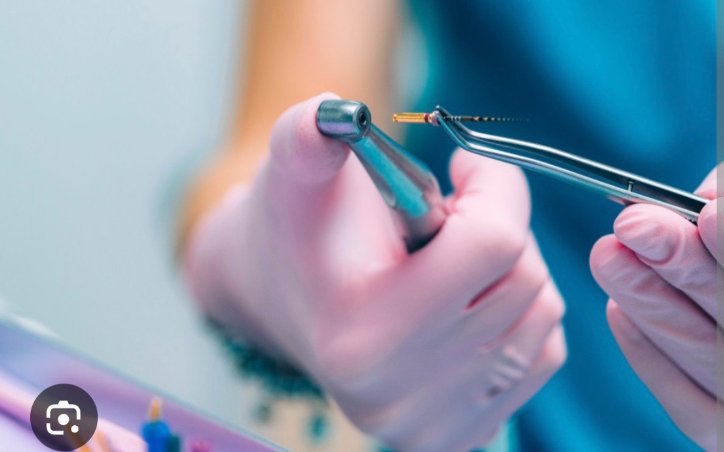 
        Ręka trzymająca narzędzie dentystyczne, przygotowująca się do zabiegu.
    