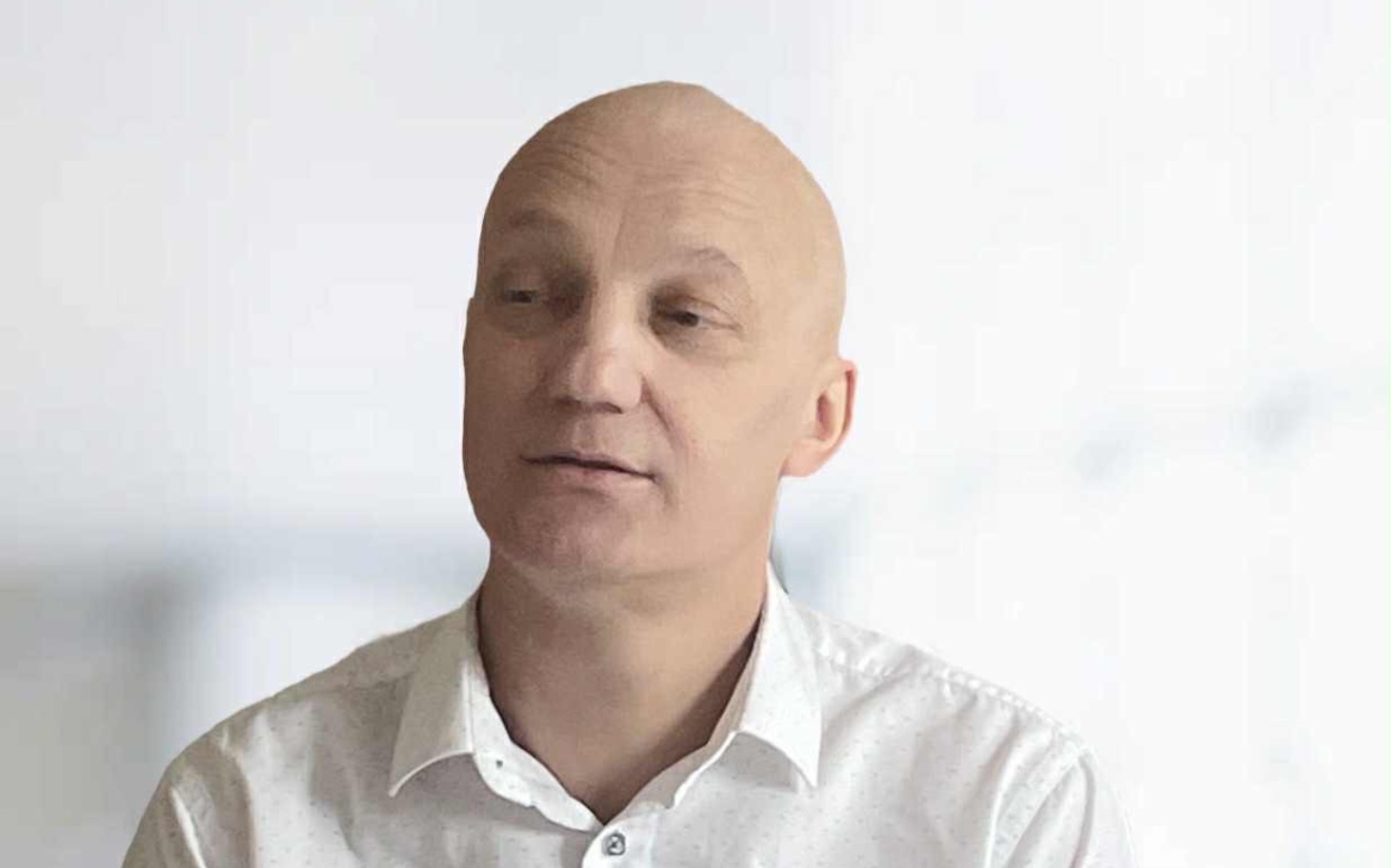 
        Mężczyzna w białej koszuli, patrzący w dal.
    