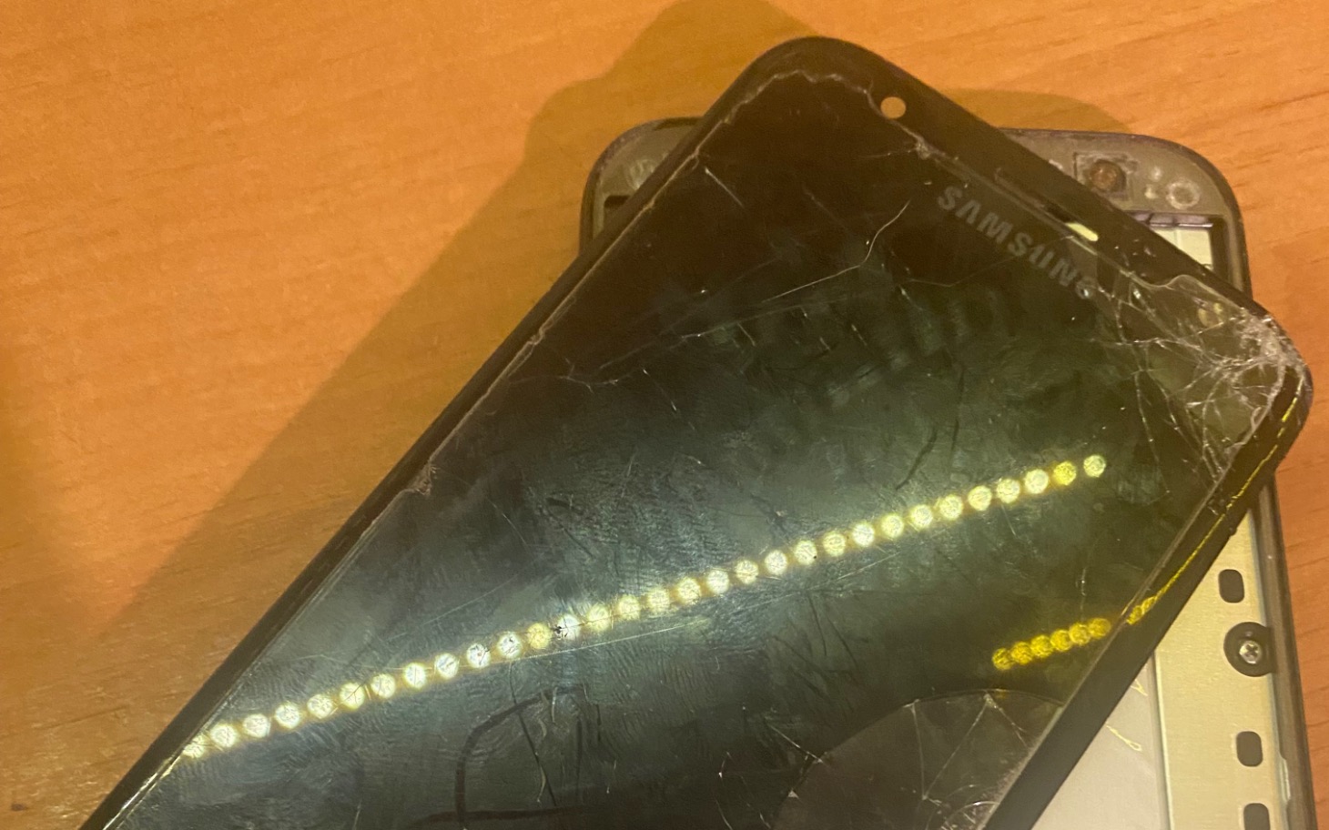 
        Zniszczony telefon Samsung z pękniętym ekranem.
    