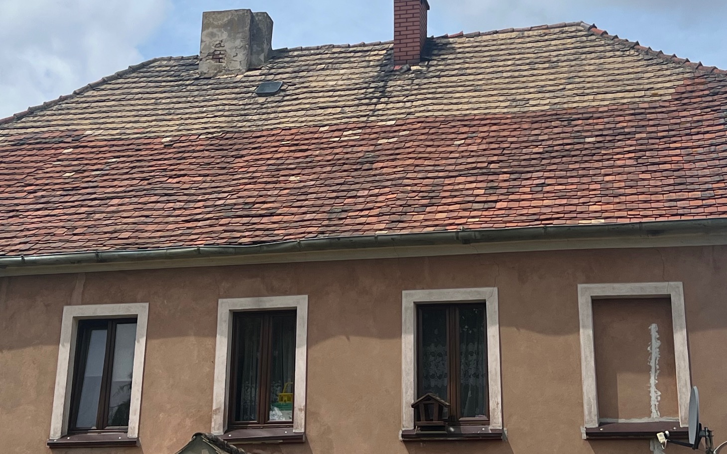 
        Zniszczony dach budynku z widocznymi uszkodzeniami.
    