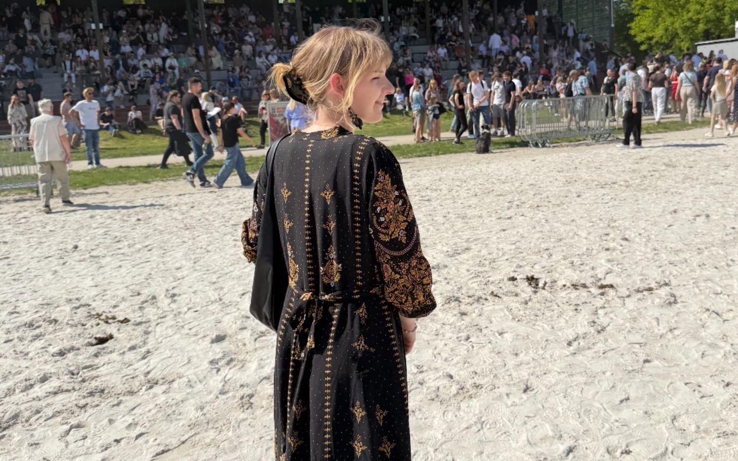
        Kobieta w eleganckiej sukience na festiwalu.
    