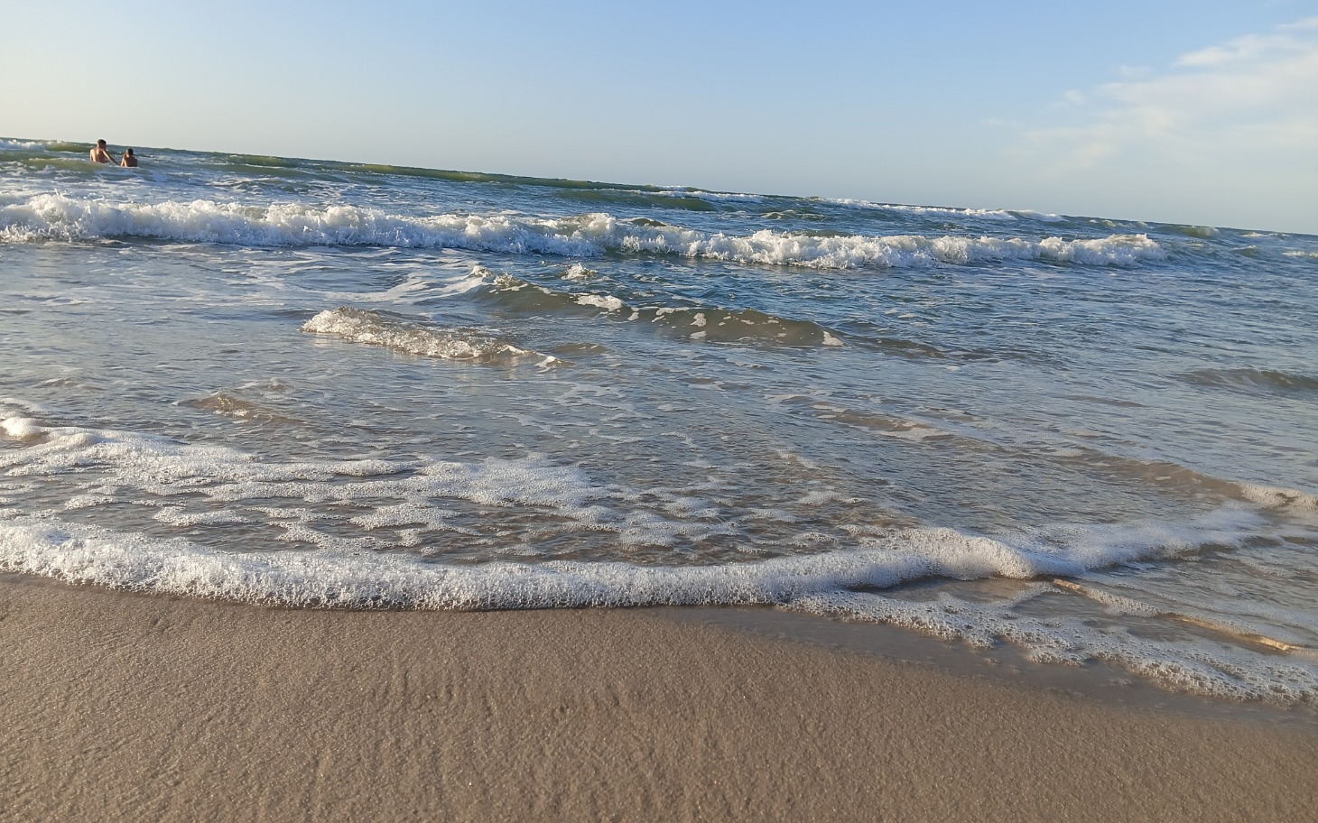 
        Fale morskie na plaży, spokojny widok na morze.
    