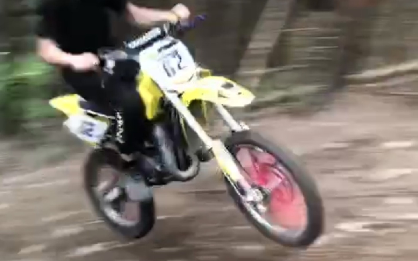 
        Chłopak skaczący na motocyklu w lesie.
    