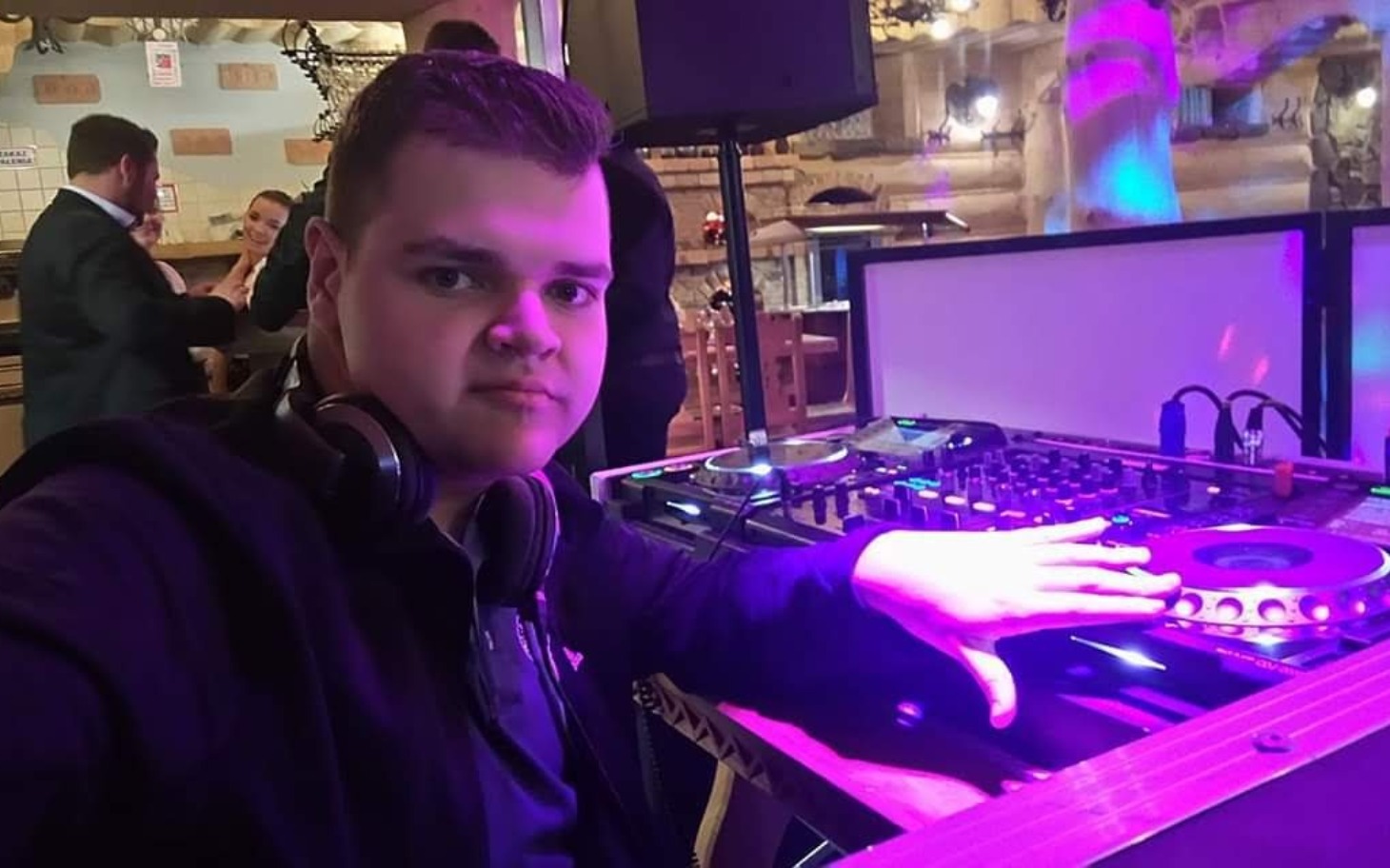 
        Młody DJ przy konsoli, gotowy do zabawy.
    