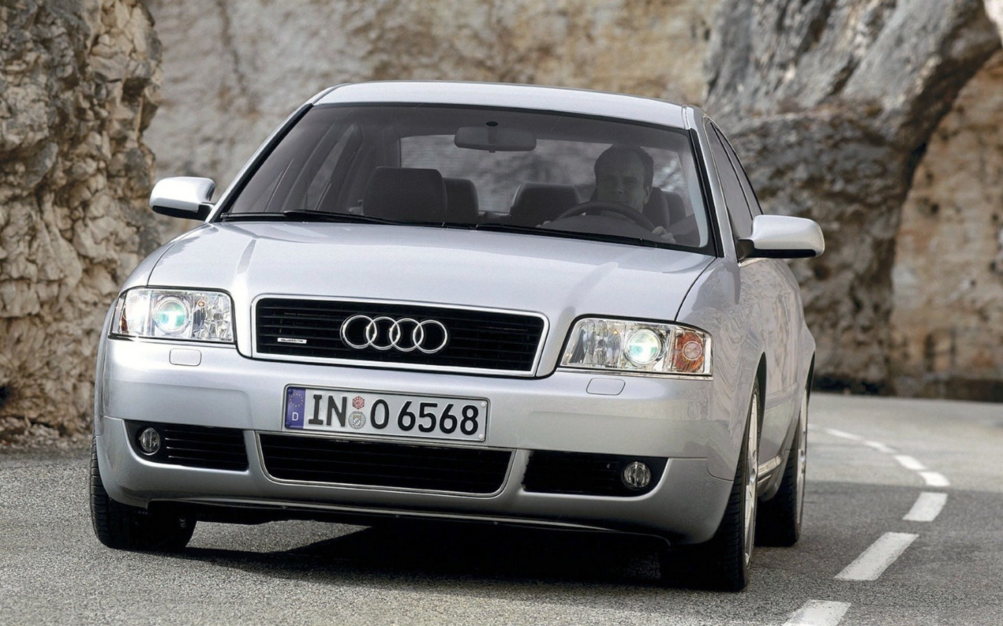 
        Srebrne Audi na krętej drodze w górach.
    