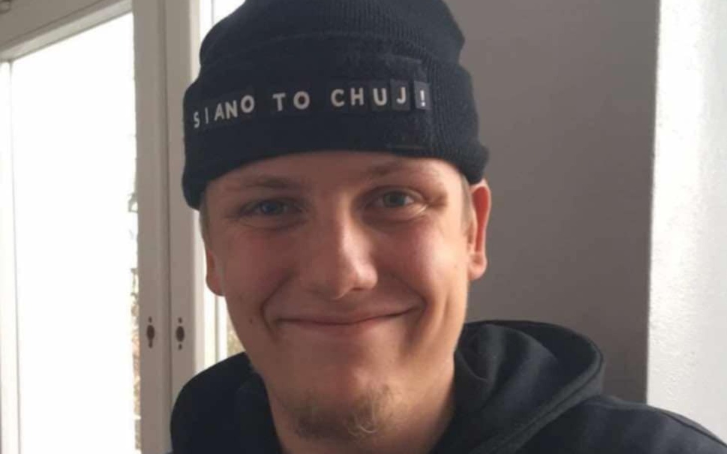 
        Mężczyzna w czapce z uśmiechem na twarzy.
    