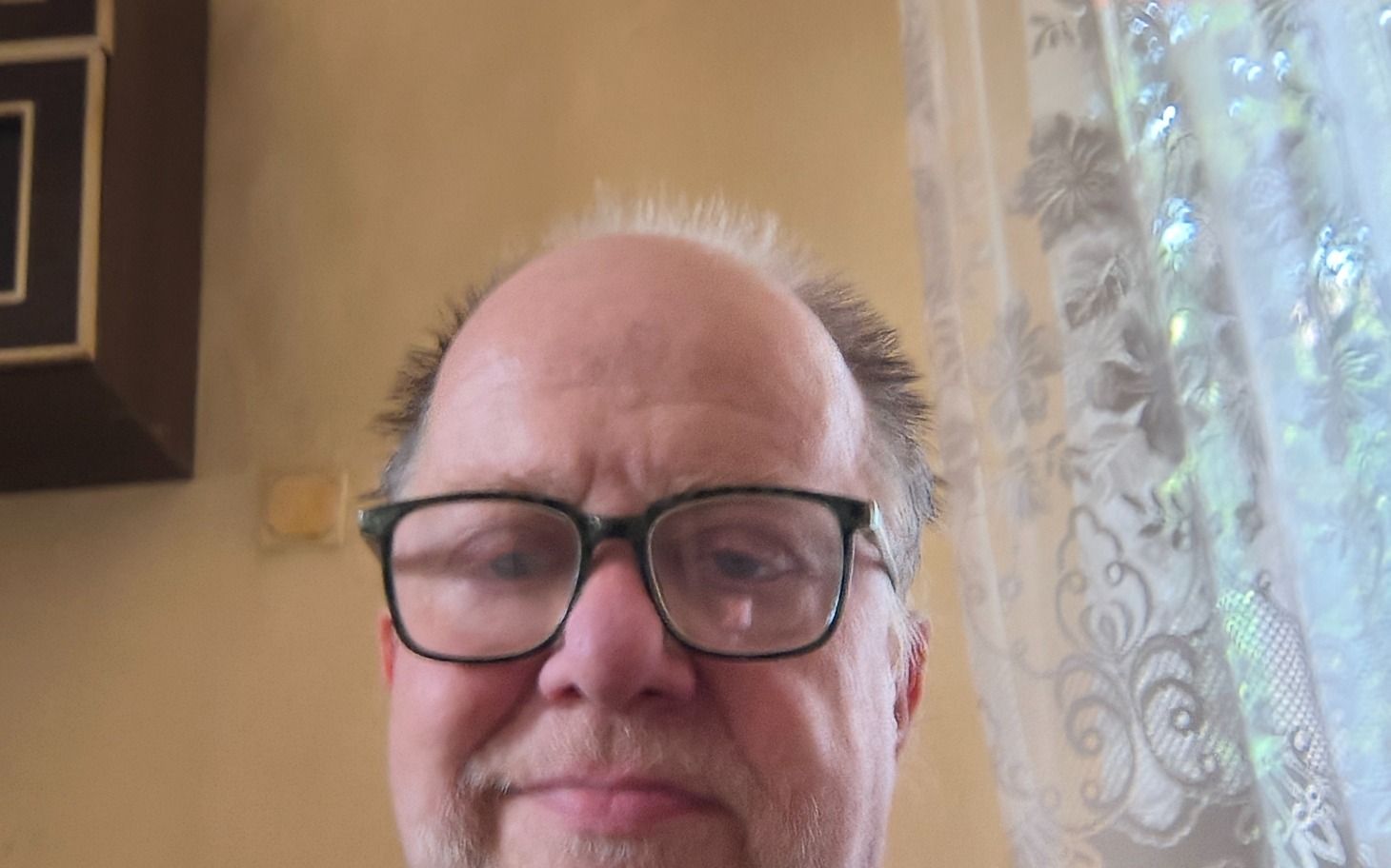 
        Mężczyzna w okularach, uśmiechający się do kamery.
    