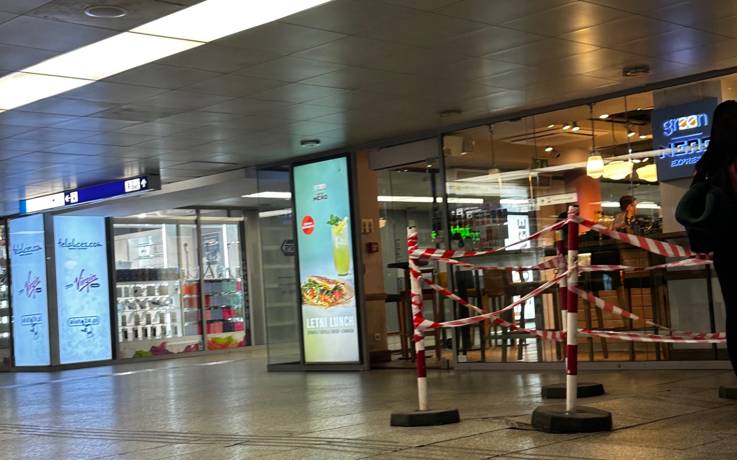 
        Widok na zamknięty lokal w centrum handlowym z taśmą ostrzegawczą.
    