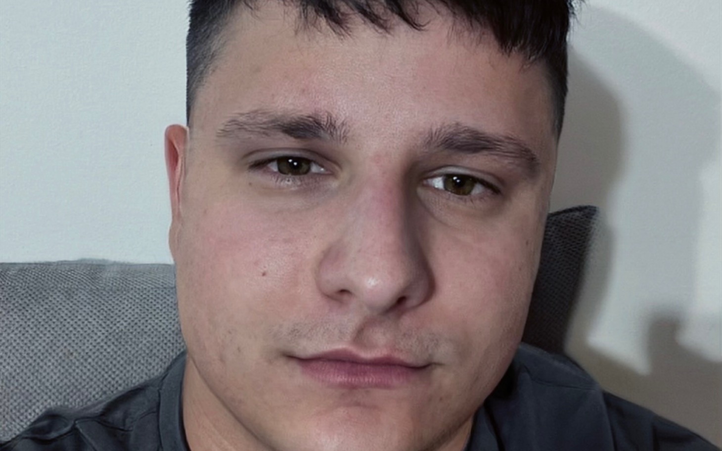 
        Mężczyzna robiący selfie, siedząc na kanapie.
    