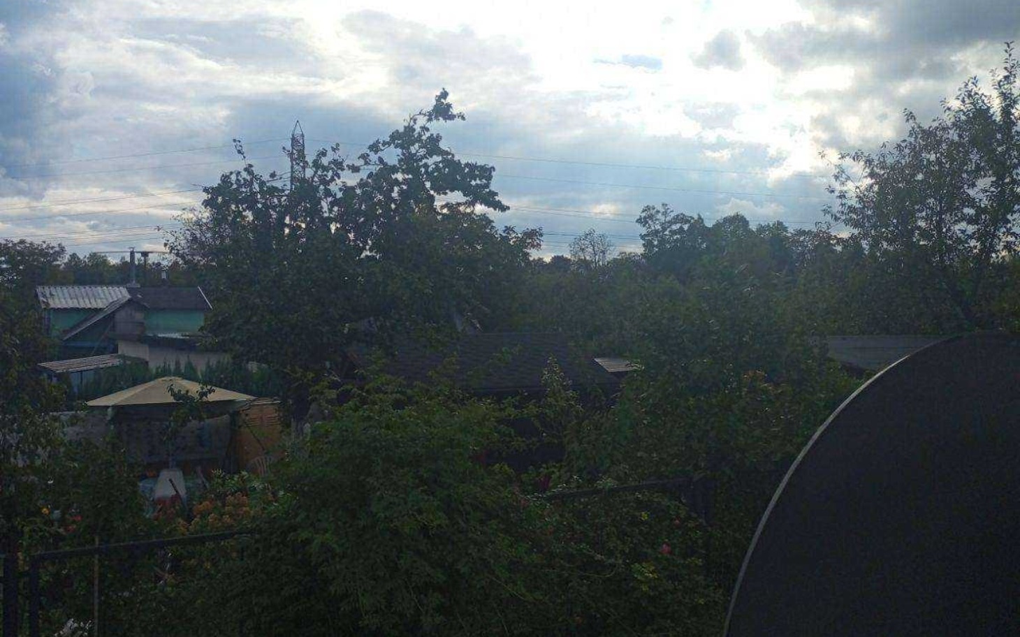 
        Widok na zielony krajobraz z drzewami i chmurami na niebie.
    