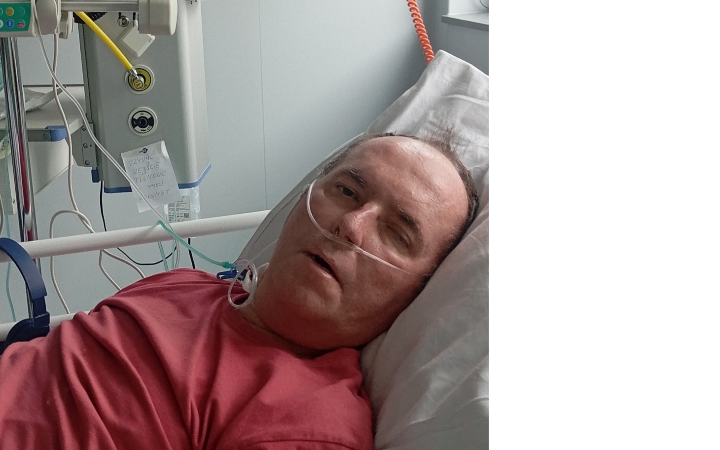 
        Mężczyzna leżący w szpitalnym łóżku, z tlenem na twarzy.
    