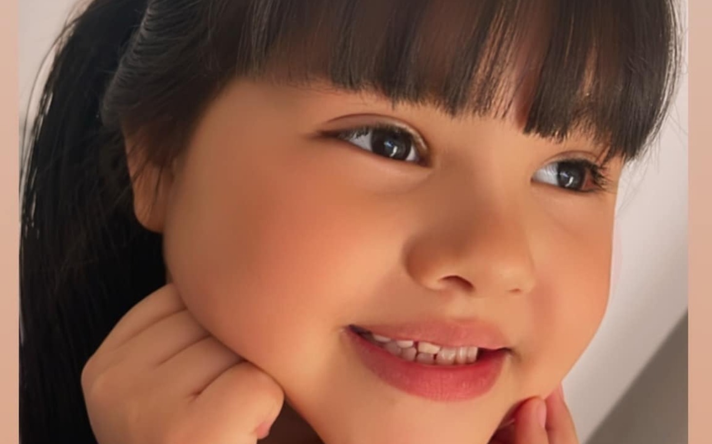 
        Uśmiechnięta dziewczynka z długimi włosami.
    