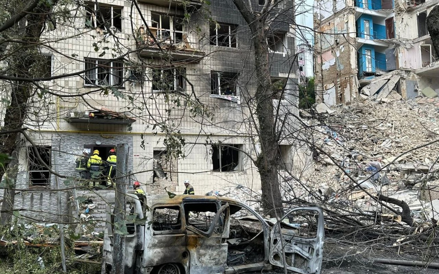 
        Zniszczony budynek po katastrofie, z ratownikami w akcji.
    