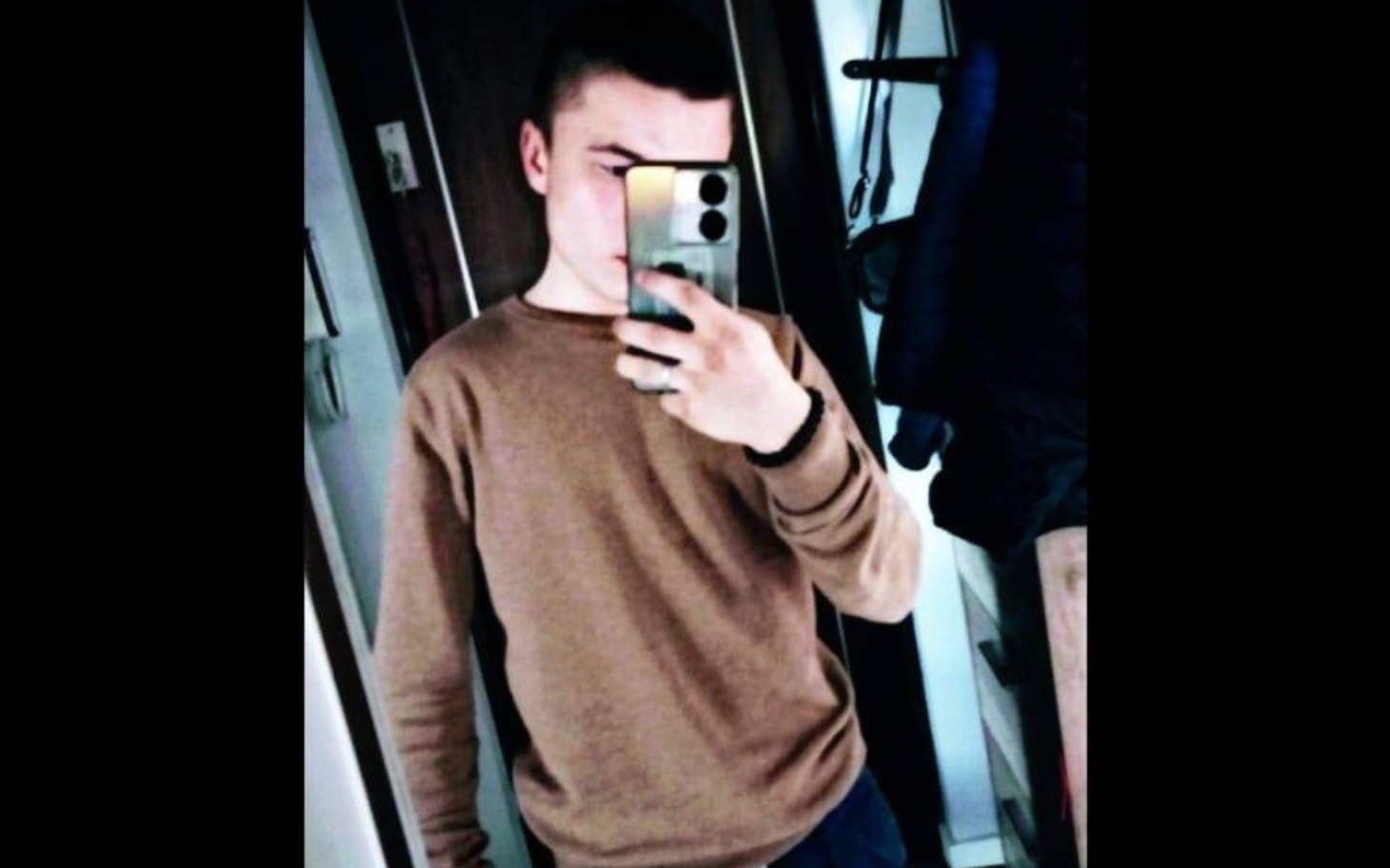 
        Młody mężczyzna robiący selfie w lustrze.
    