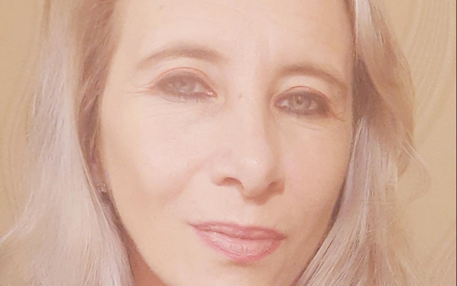 
        Portret kobiety z jasnymi włosami i delikatnym uśmiechem.
    