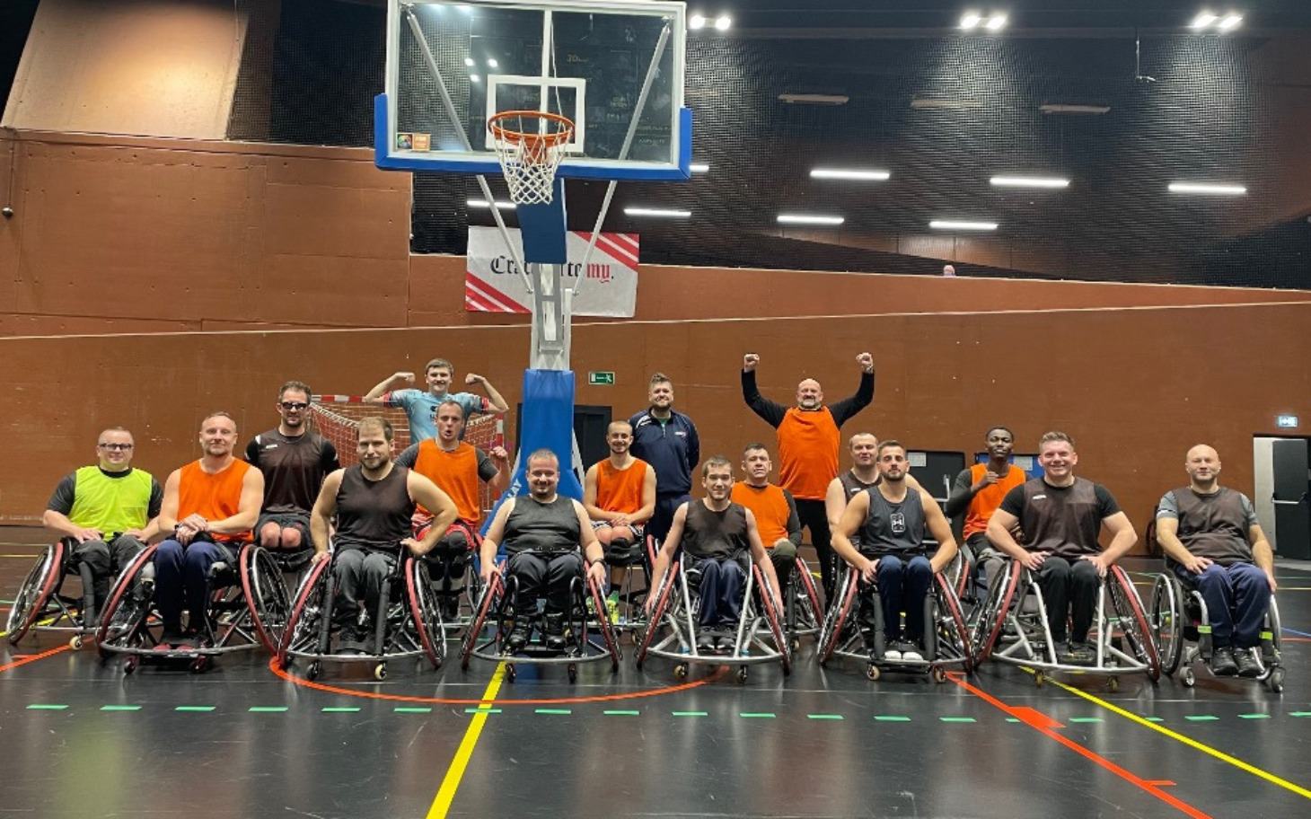 
        Zespół koszykarzy na wózkach inwalidzkich w hali sportowej.
    