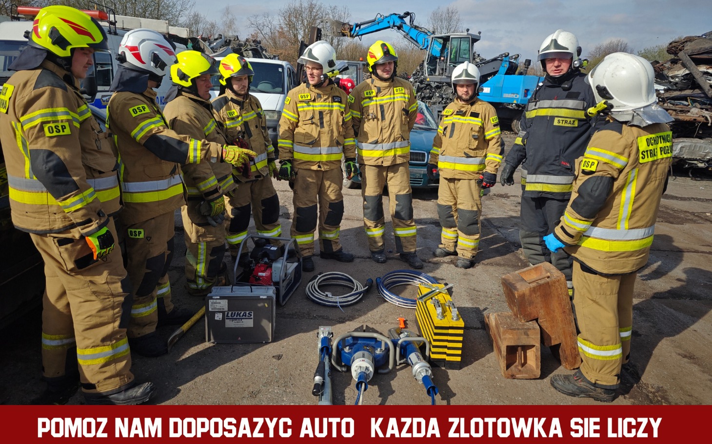 
        Grupa strażaków w mundurach omawia sprzęt ratunkowy.
    