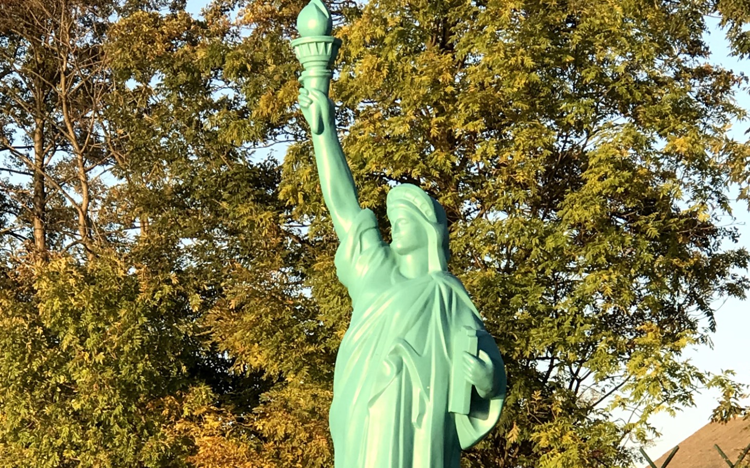 
        Statua Wolności w otoczeniu zieleni, symbol wolności.
    