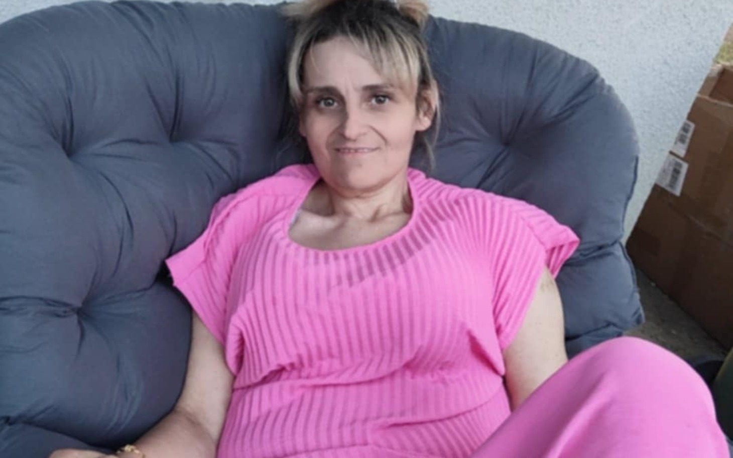 
        Kobieta w różowej sukience, siedząca na kanapie.
    