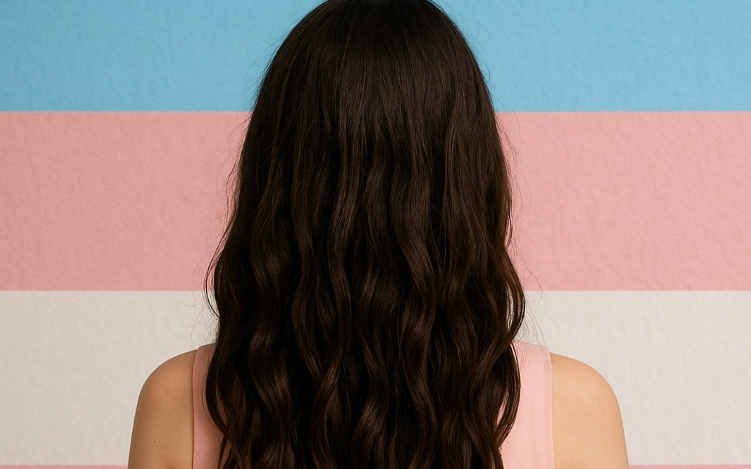 
        Widok na długie, falowane włosy na tle kolorowych pasów.
    