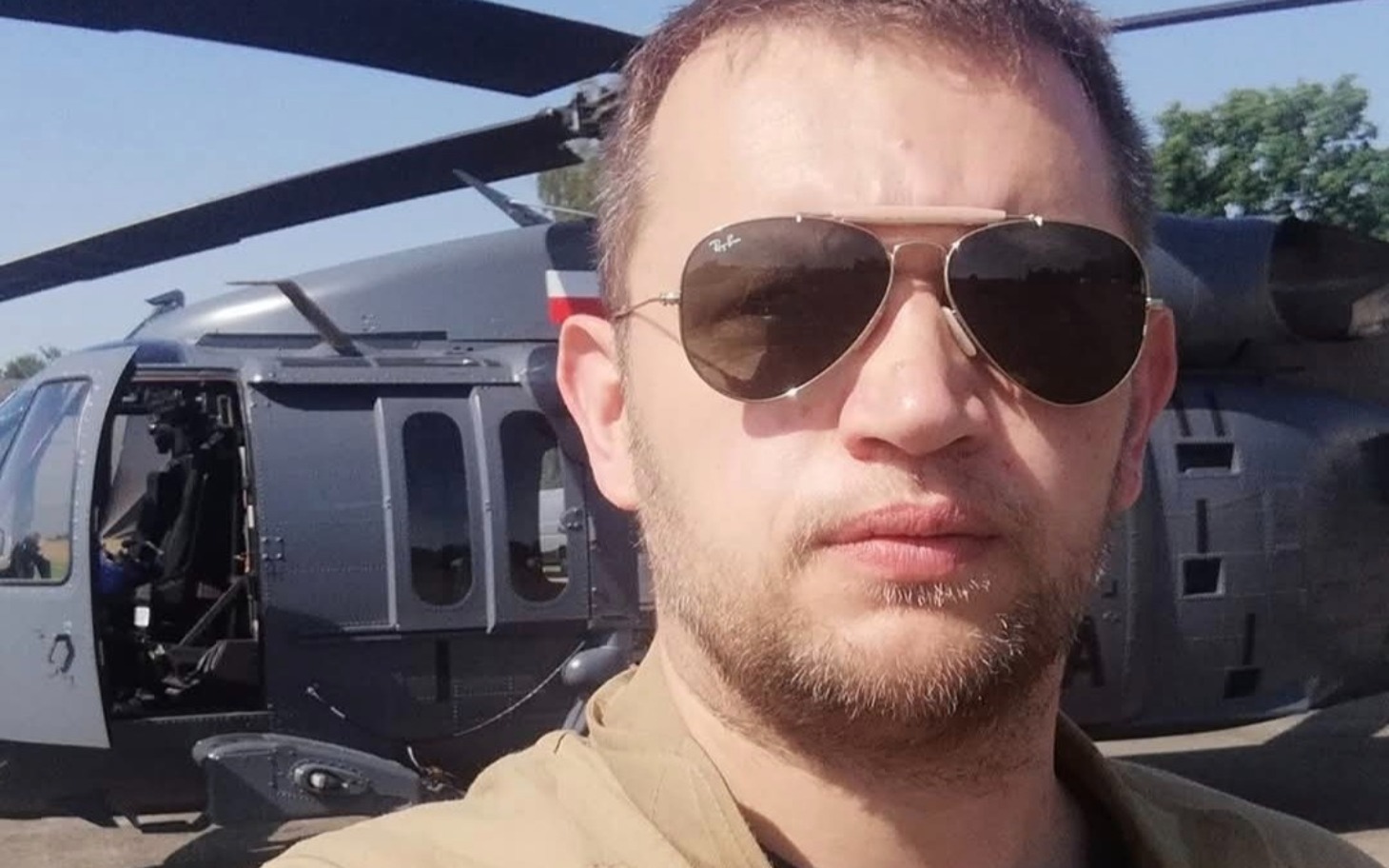 
        Mężczyzna w okularach przeciwsłonecznych przy helikopterze.
    